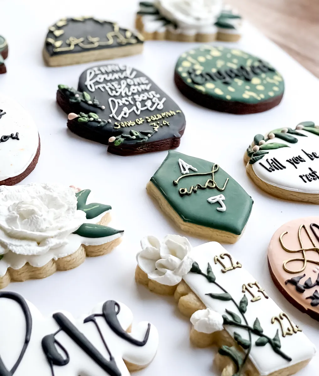 Engagement cookies in forest green, black and gold with Engaged lettering, a Song of Solomon verse, white buttercream peony and monogram