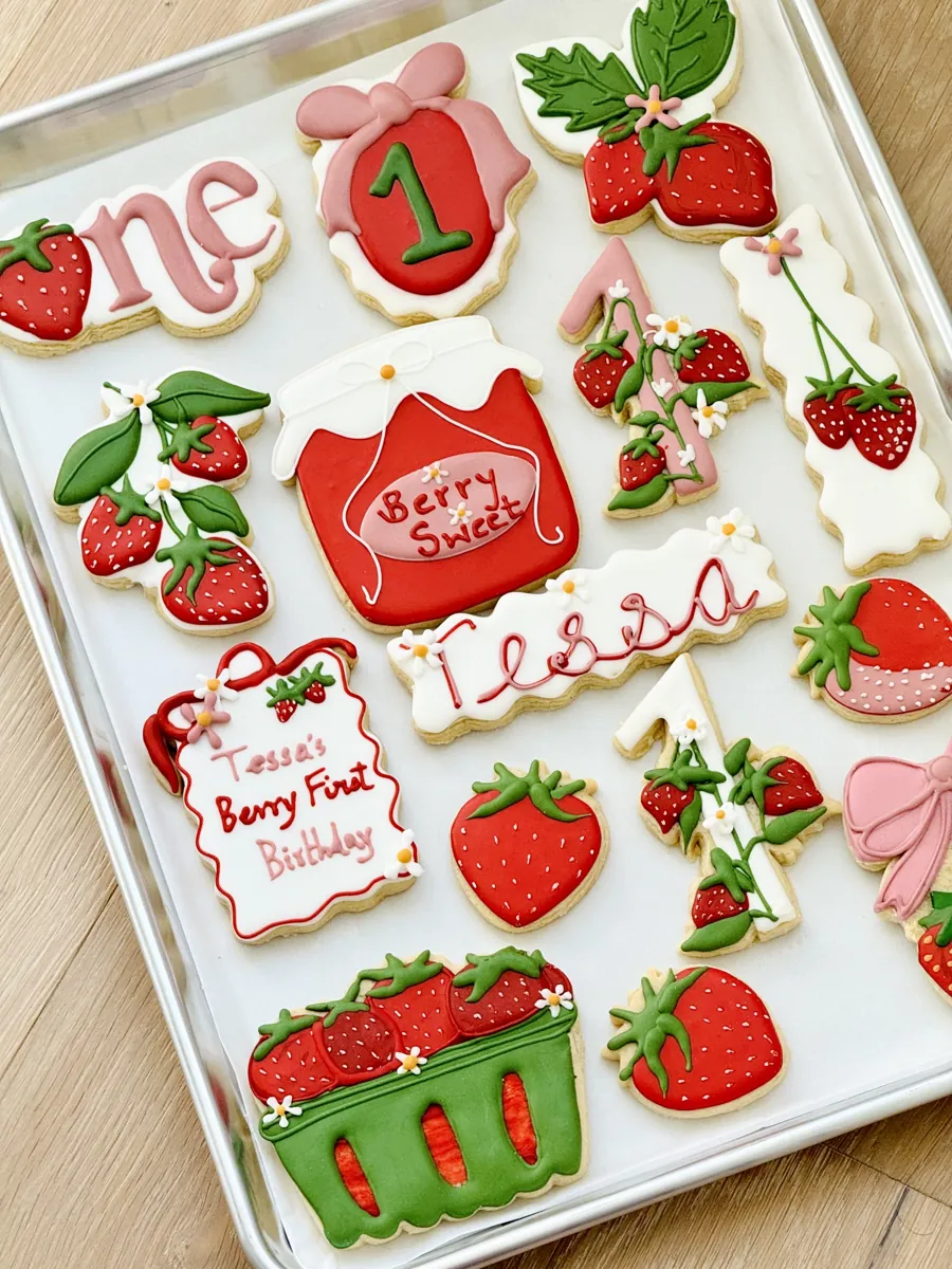 Strawberry themed first birthday cookies with berry jam jar, strawberry basket and number one cookies